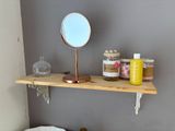 a wooden shelf with a mirror on top of it