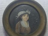 an old picture of a woman in a hat and striped dress