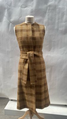 beige and brown checkered dress on display in front of a white backdrop