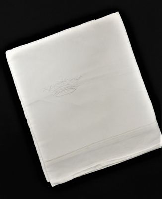 le mouchoir blanc est posé, plié, sur une table noire