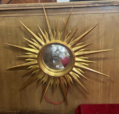 une étoile dorée accrochée au mur à côté d'une chaise rouge