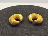 une paire de boucles d'oreilles plaquées or sur un fond noir