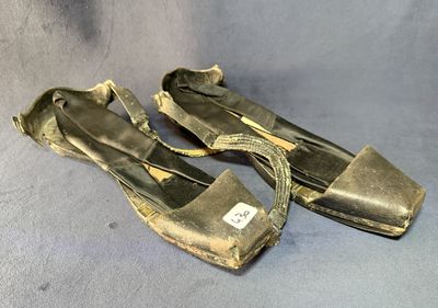 deux paires de vieilles chaussures sont posées sur une surface bleue