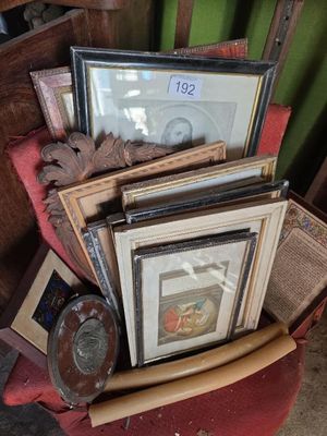 une pile de photos encadrées et une horloge posée sur une chaise