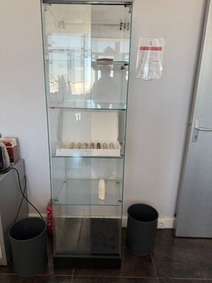 une vitrine en verre dans le coin d'une pièce