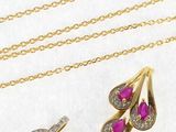 two gold necklaces and a pair of ruby and diamond earrings