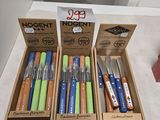 Plusieurs stylos de différentes couleurs se trouvent dans une boîte posée sur un comptoir.