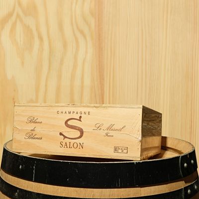 a wooden box sitting on top of a barrel of wine