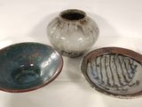 three bowls and a bowl sitting on a white surface