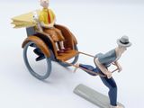 toy figurine of a man pulling a horse drawn carriage with a dog