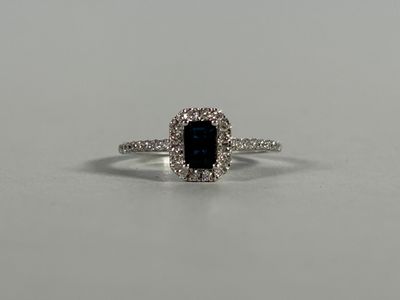a blue sapphire and diamond ring on a white surface