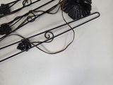 a metal sculpture of a bunch of flowers hanging on a wall