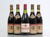 six bottles of red wine are lined up on a table