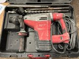 une perceuse à fil rouge dans une mallette avec d'autres outils