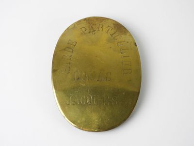 un gros plan d'une plaque en laiton posée sur une surface blanche