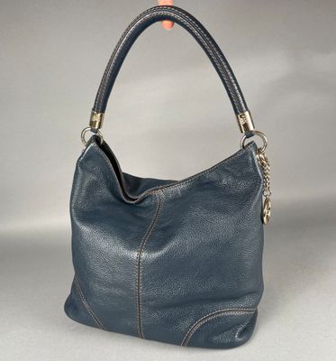 un gros plan d'un sac à main bleu posé sur une surface blanche