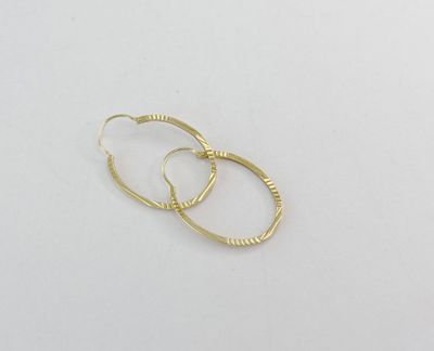 deux paires de boucles d'oreilles en or sur fond blanc