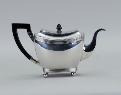 théière plaquée argent avec une poignée noire et une poignée noire