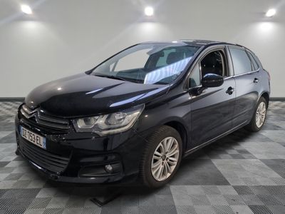 la voiture noire est garée sur un sol en damier dans le garage