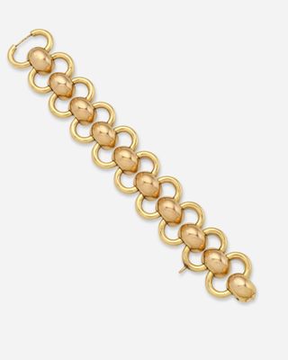 gros plan d'un bracelet en or sur fond blanc