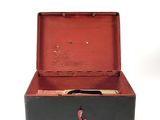 a black suitcase with a red handle sitting on a white surface