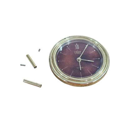 a clock that is sitting on a table next to some screws
