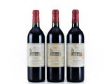trois bouteilles de vin rouge posées l'une à côté de l'autre sur une surface blanche