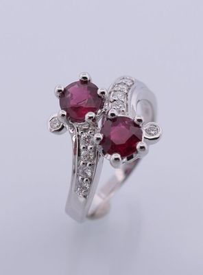 une bague en or blanc sertie de deux rubis et de diamants