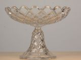 a glass bowl on a table with a white wall in the background