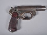 un vieux pistolet posé sur une surface blanche