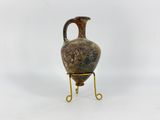 a vase that is on a stand on a white surface