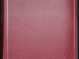 un livre rouge posé sur une table noire