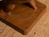 a bronze statue of a dog on a wooden table