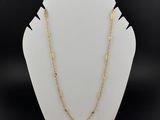un collier à chaîne en or avec un fermoir en or sur un mannequin blanc