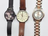trois montres différentes sont posées sur une surface blanche, sur fond blanc