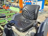 a tractor with a seat that is sitting in the dirt