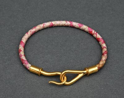 a close up of a pink and gold bracelet with a hook