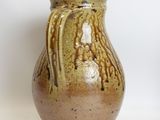 two brown vases sitting next to each other on a white surface