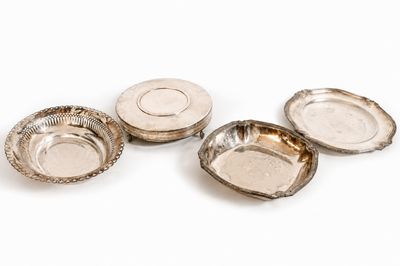 quatre assiettes plaquées argent sur un fond blanc
