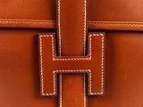 a brown leather handbag with a metal clasp