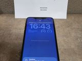 Un iPhone est posé sur une table, à côté d'un panneau.