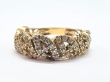 a close up of a gold and diamond ring on a white surface