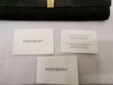 a black purse and two business cards on a table
