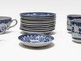 many blue and white cups and saucers on the table