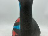 a black vase with a red and blue design on it