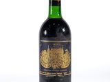 une vieille bouteille de vin posée sur une surface blanche