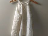 une robe blanche suspendue à un cintre accroché au mur
