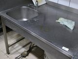 une cuisine en inox équipée d'un évier et d'un plan de travail