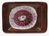 purple and white plate with a flower design on it on a white background
