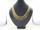gold plated necklace on a black mannequin with a white background